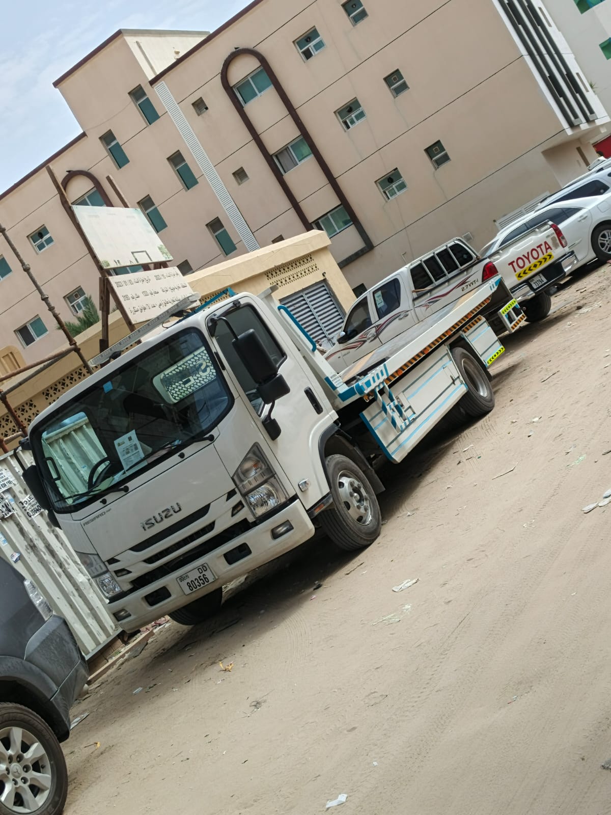 Flatbed tow truck handling a vehicle in Sharjah
